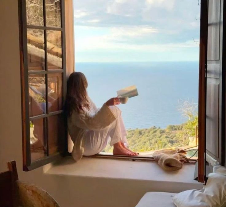 Persona reflexiva mirando por la ventana en verano, ilustrando la decisión de dejar la terapia en verano