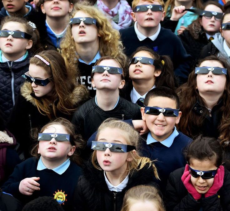 Personas mirando el eclipse solar de agosto de 2026 con asombro, ilustrando la psicología de los grandes eventos naturales